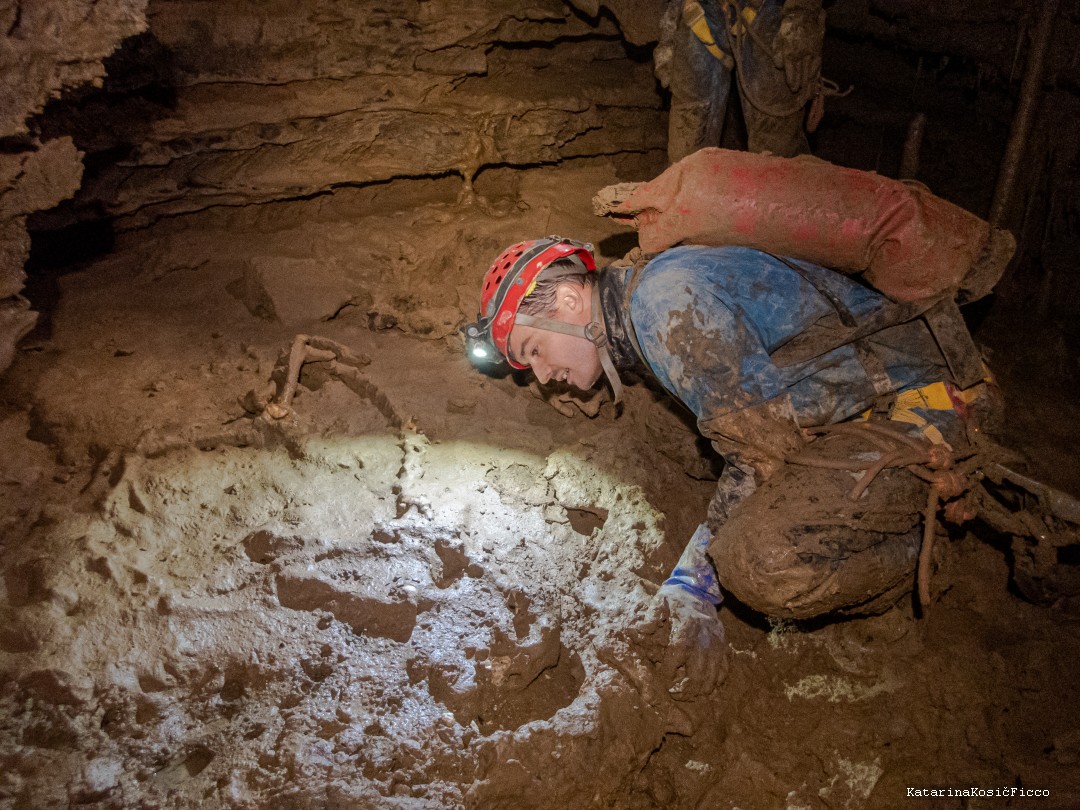 Inspecting skeleton in the cave.